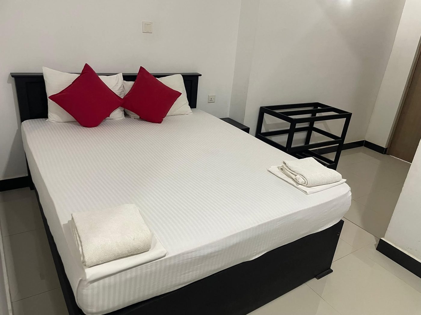 Comfortable double room with crisp white bedding and red cushions